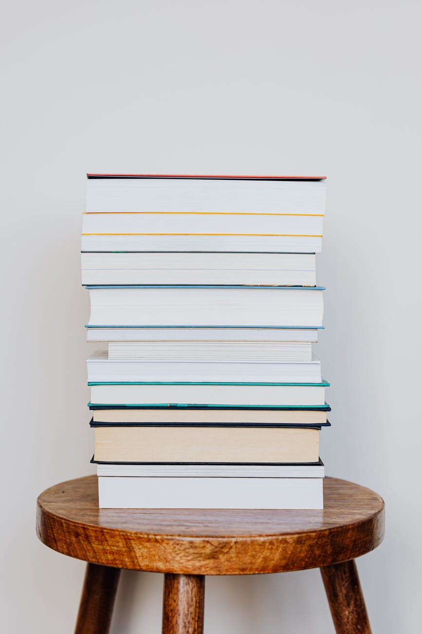 big pile of books on wooden stool